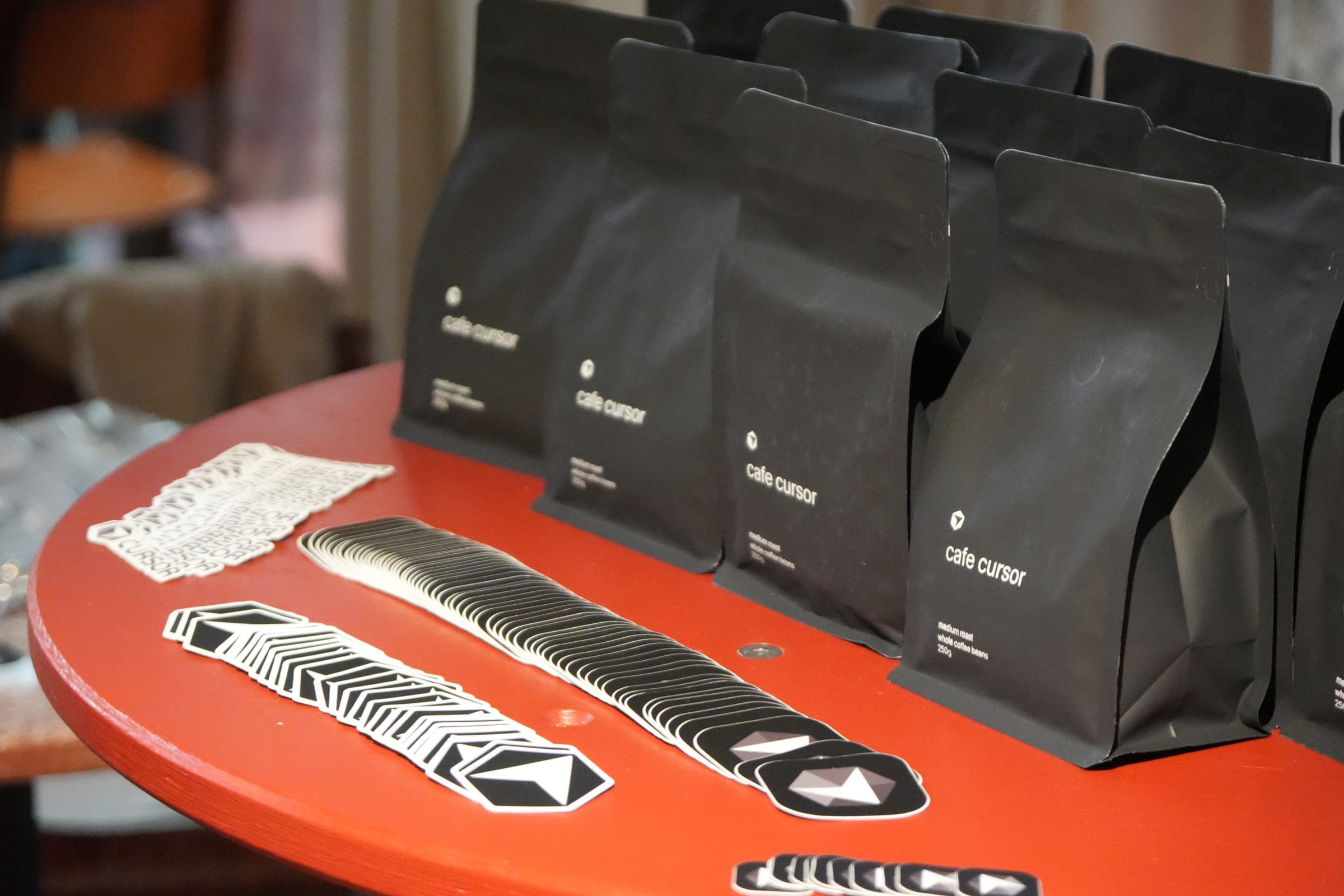 Cafe Cursor Ghent, 23 May 2026. Coffee bags and hexagonal Cursor stickers.