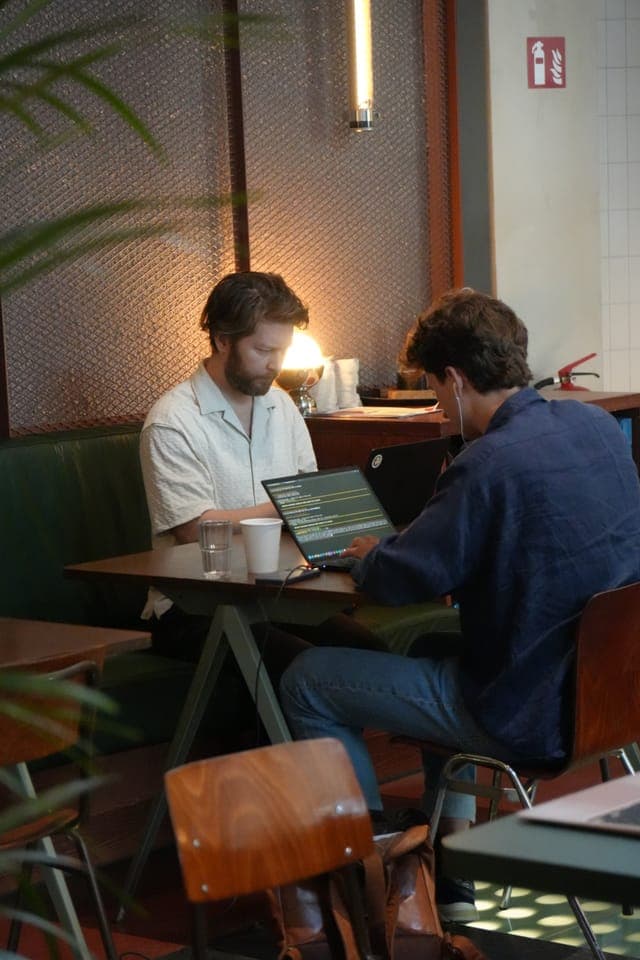 Cafe Cursor Ghent, 23 May 2026. Two builders coding at a table.