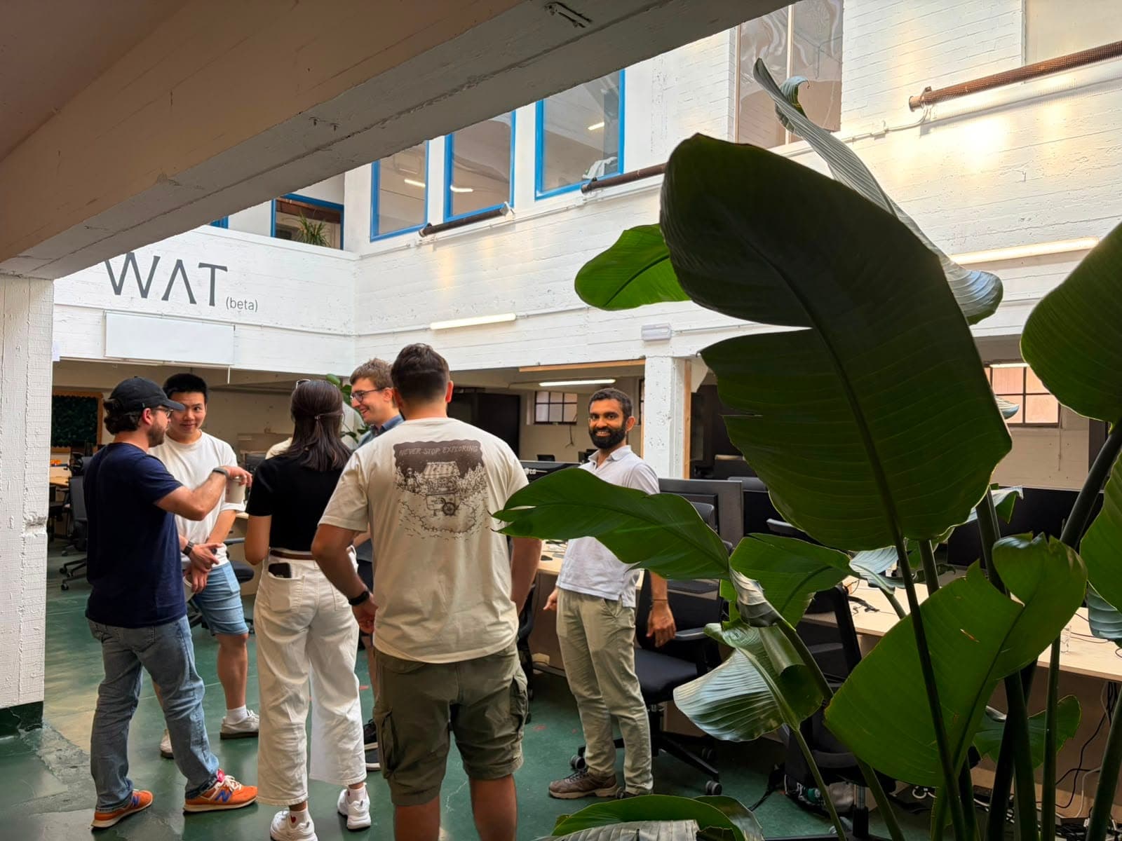 Cursor Meetup Brussels at WAT.BXL, 1 August 2026. WAT (beta) workspace and attendees talking.