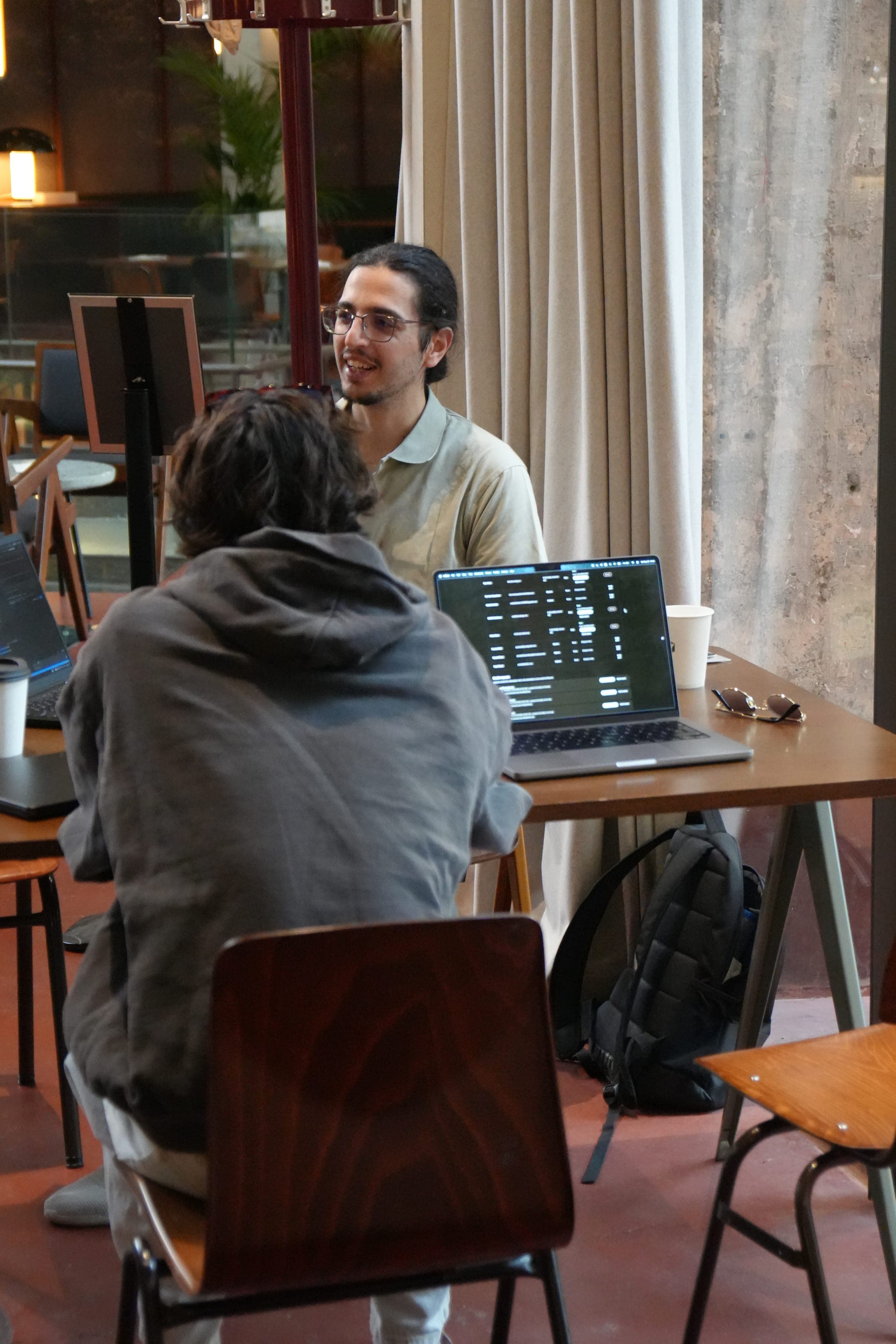 Cafe Cursor Ghent, 23 May 2026. Two attendees talking over a laptop.